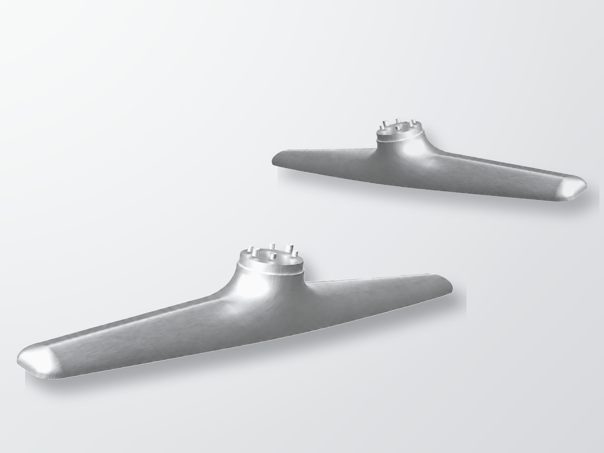 Two one-piece die-cast aluminum desk feet arranged as a studio still life