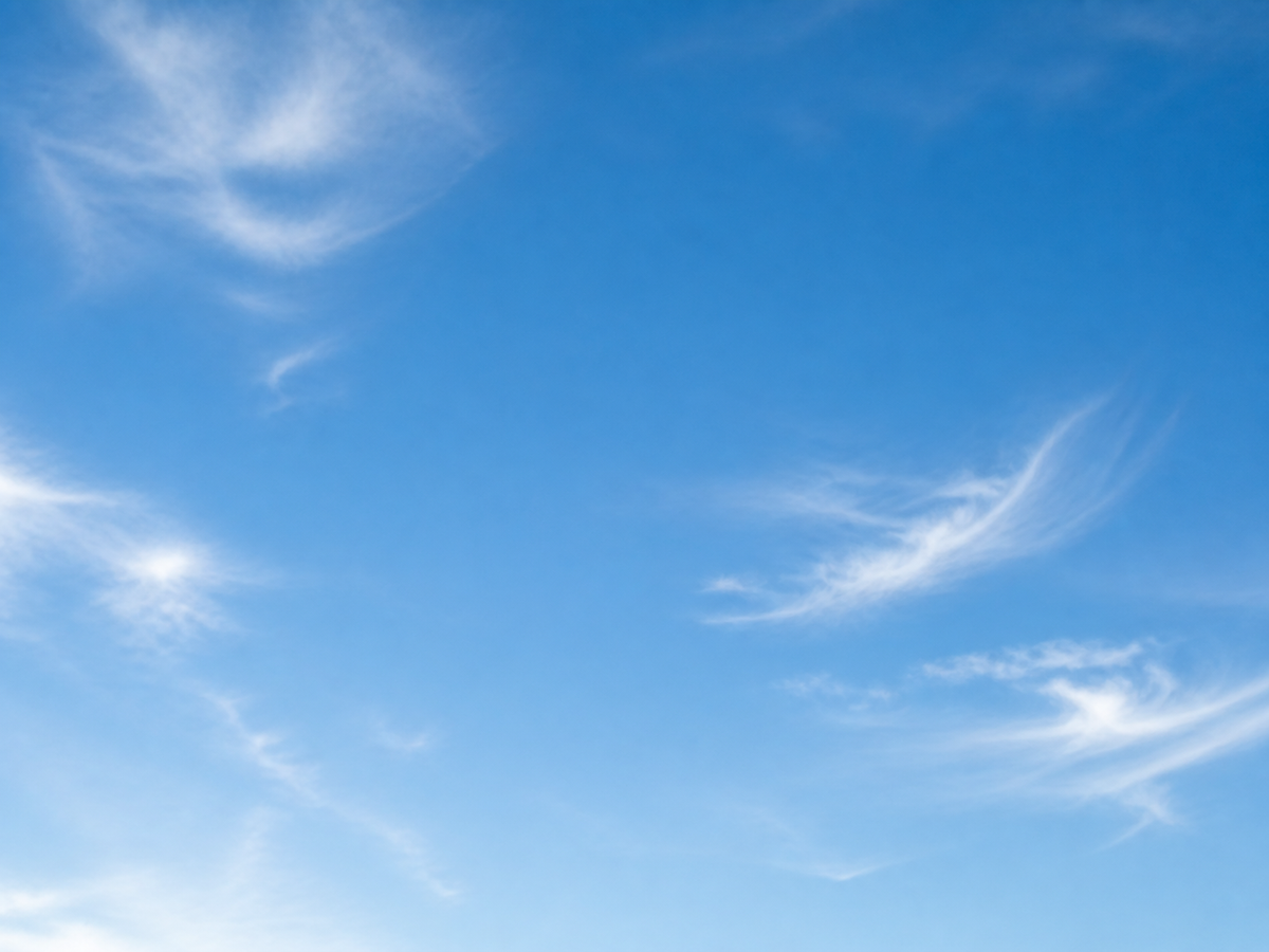 Clear blue sky with soft clouds