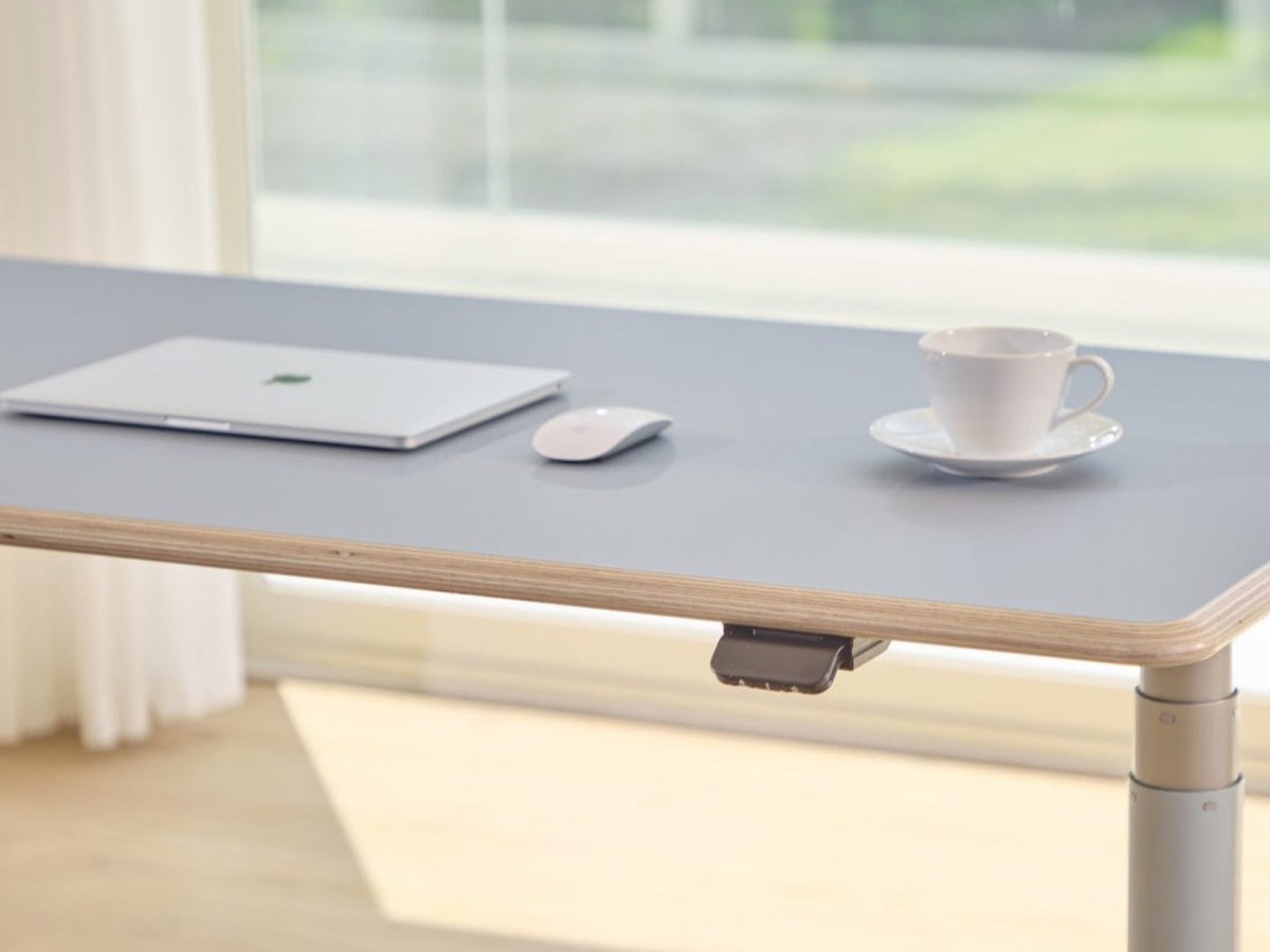 Clear Sky Blue Ease Standing Desk showing the DacroSoft surface, layered edge, and under-edge paddle
