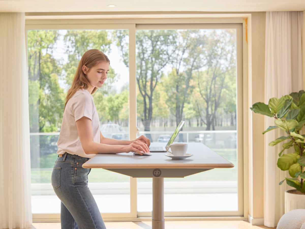 Woman working at the Ease Standing Desk in a standing position