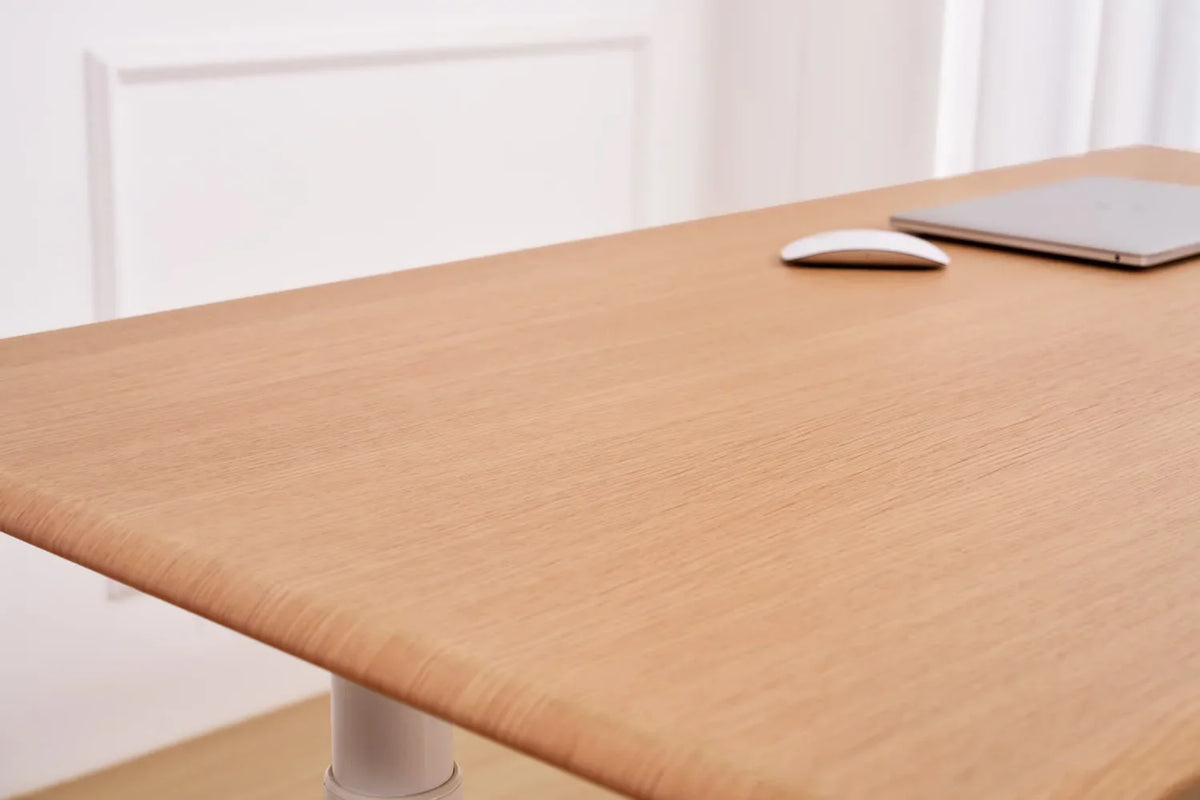 White-oak veneer grain across the Essential One Standing Desk surface and softened front edge