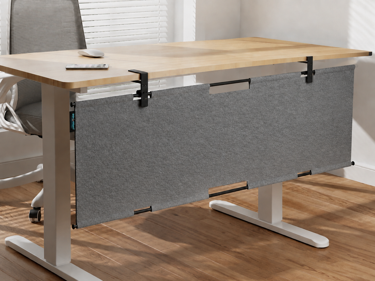 Gray felt privacy panel mounted beneath a standing desk