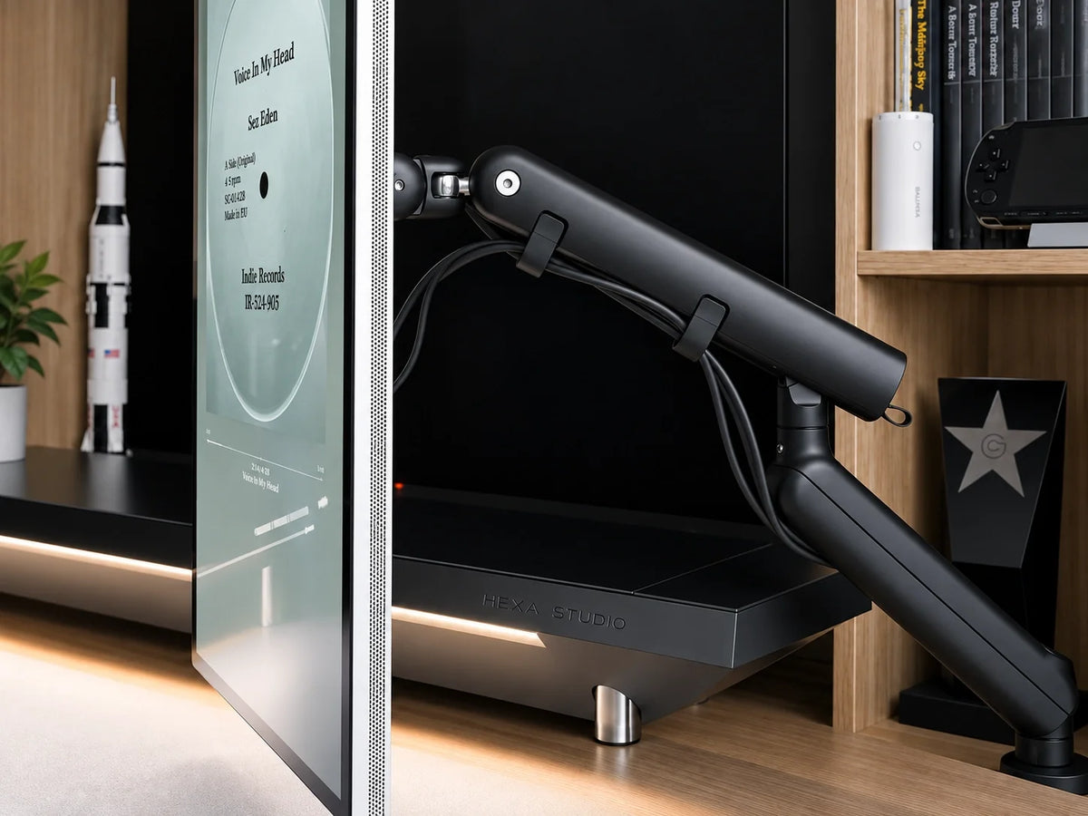 M2 black single-monitor arm side view in a workspace