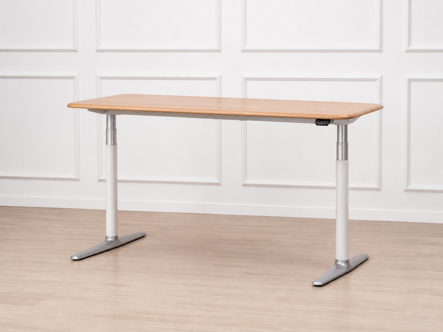 Solid white oak standing desk showing its dual-column frame and metal feet
