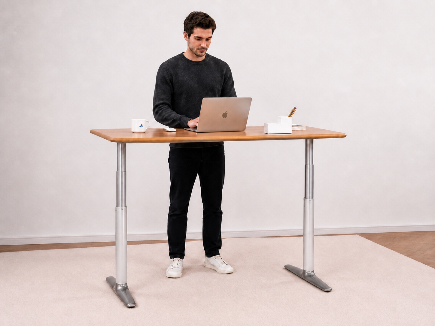 Person working at the solid white oak standing desk at standing height