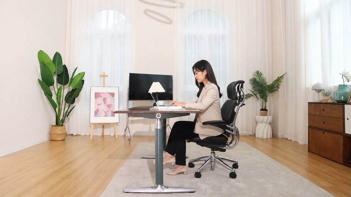 Person working seated at the Black with Silver solid walnut desk