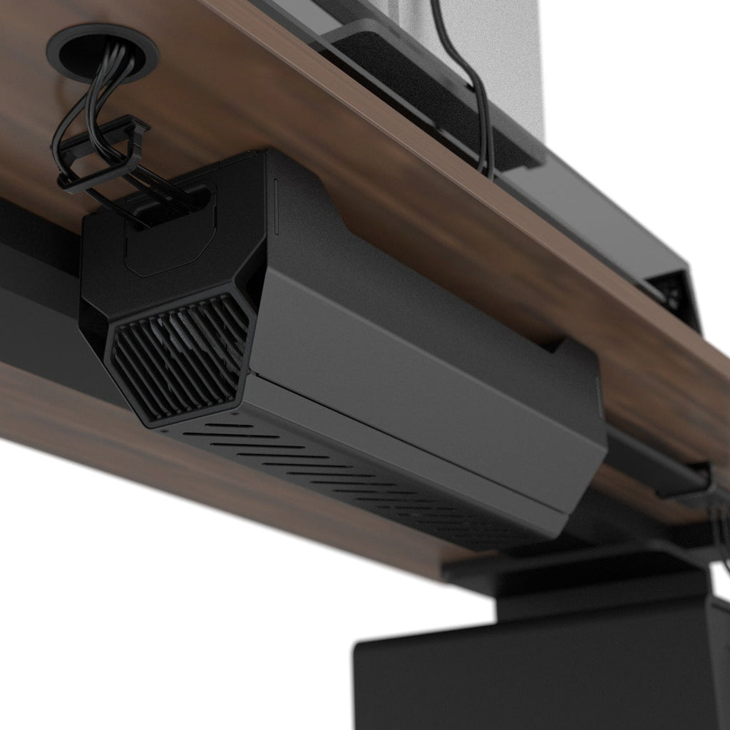 Closed black cable management box installed beneath a wood desktop