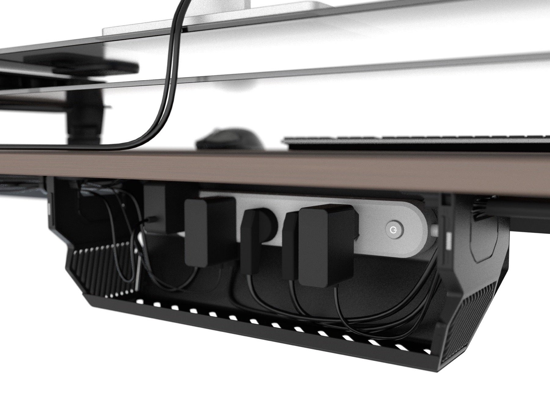 Open under-desk box holding a power strip, adapters, and routed cables