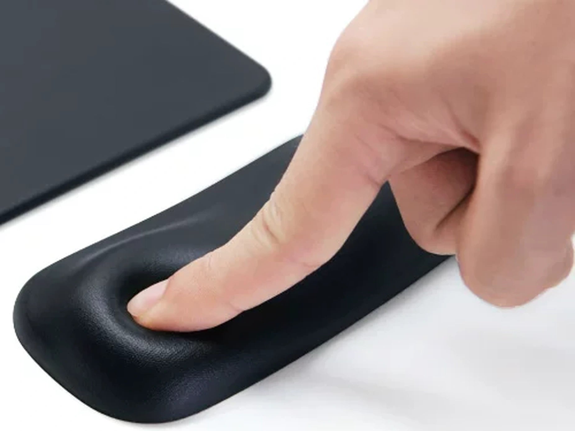 Finger pressing into the responsive black gel wrist rest core