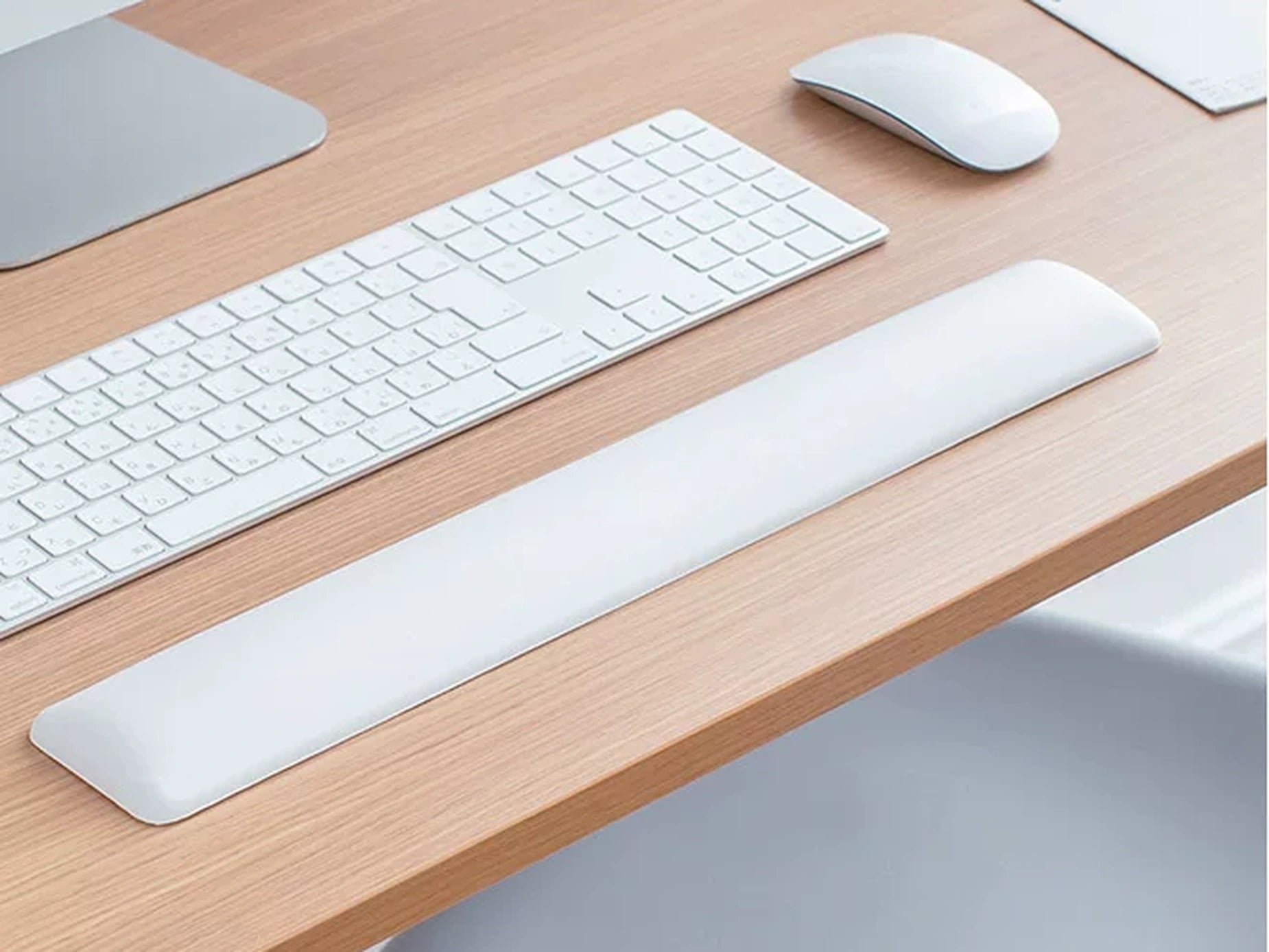 White keyboard wrist rest positioned beneath a white keyboard